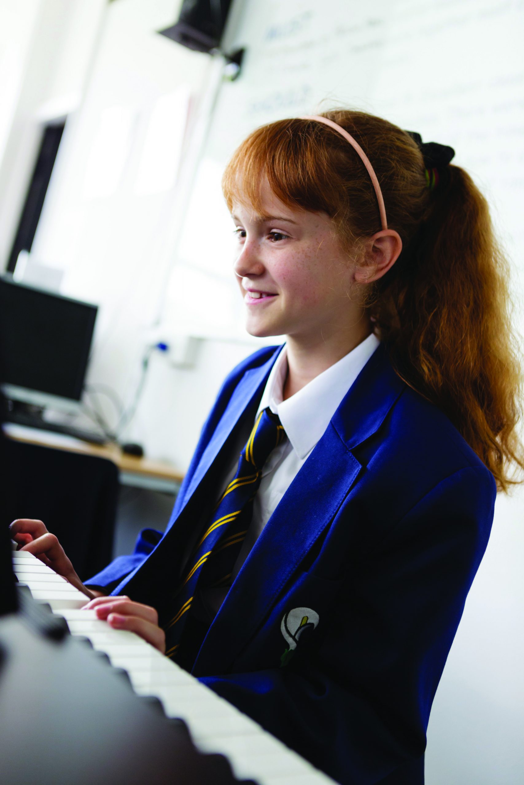 A girl in school uniform playing the piano