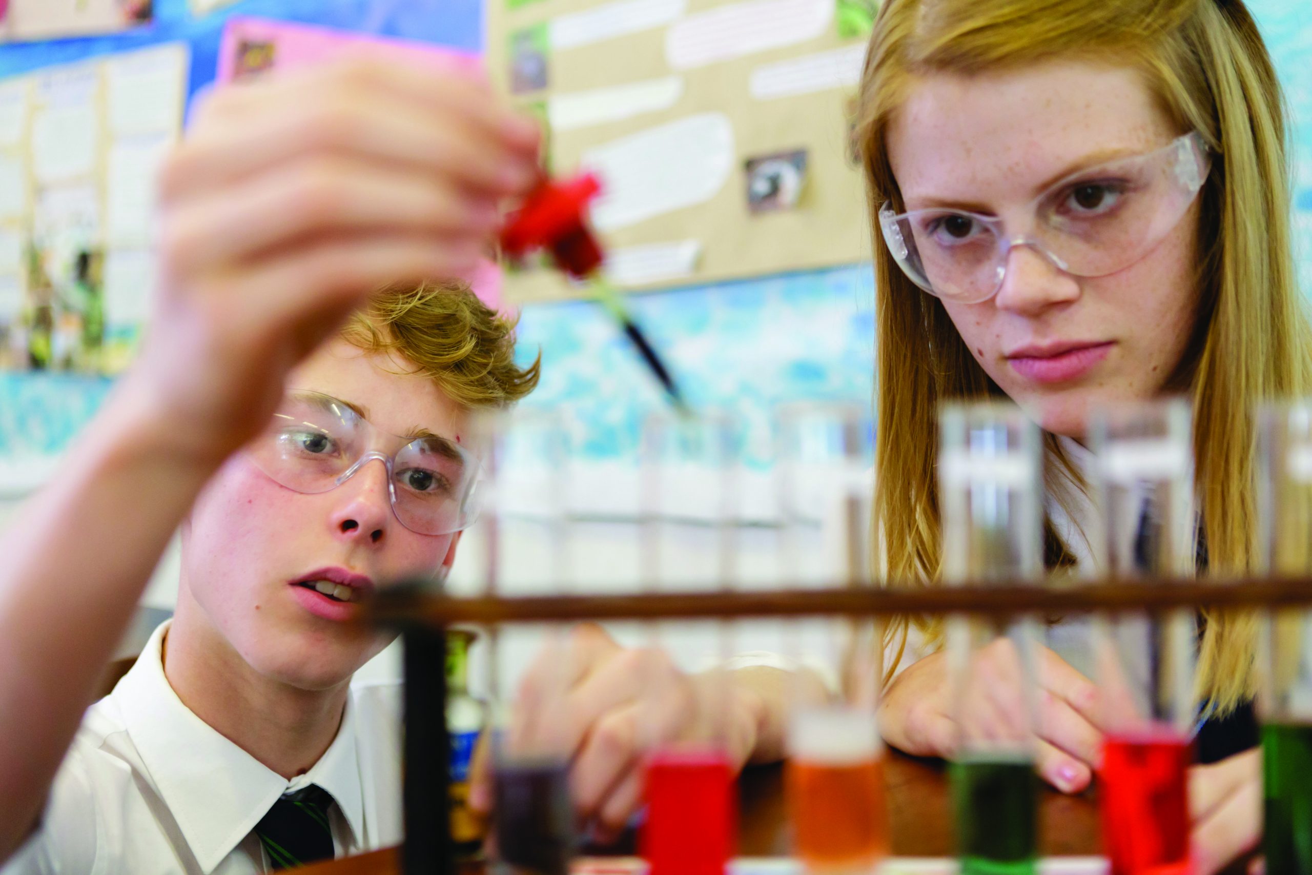 A boy and a girl doing a science experiment with test tubes and pipettes