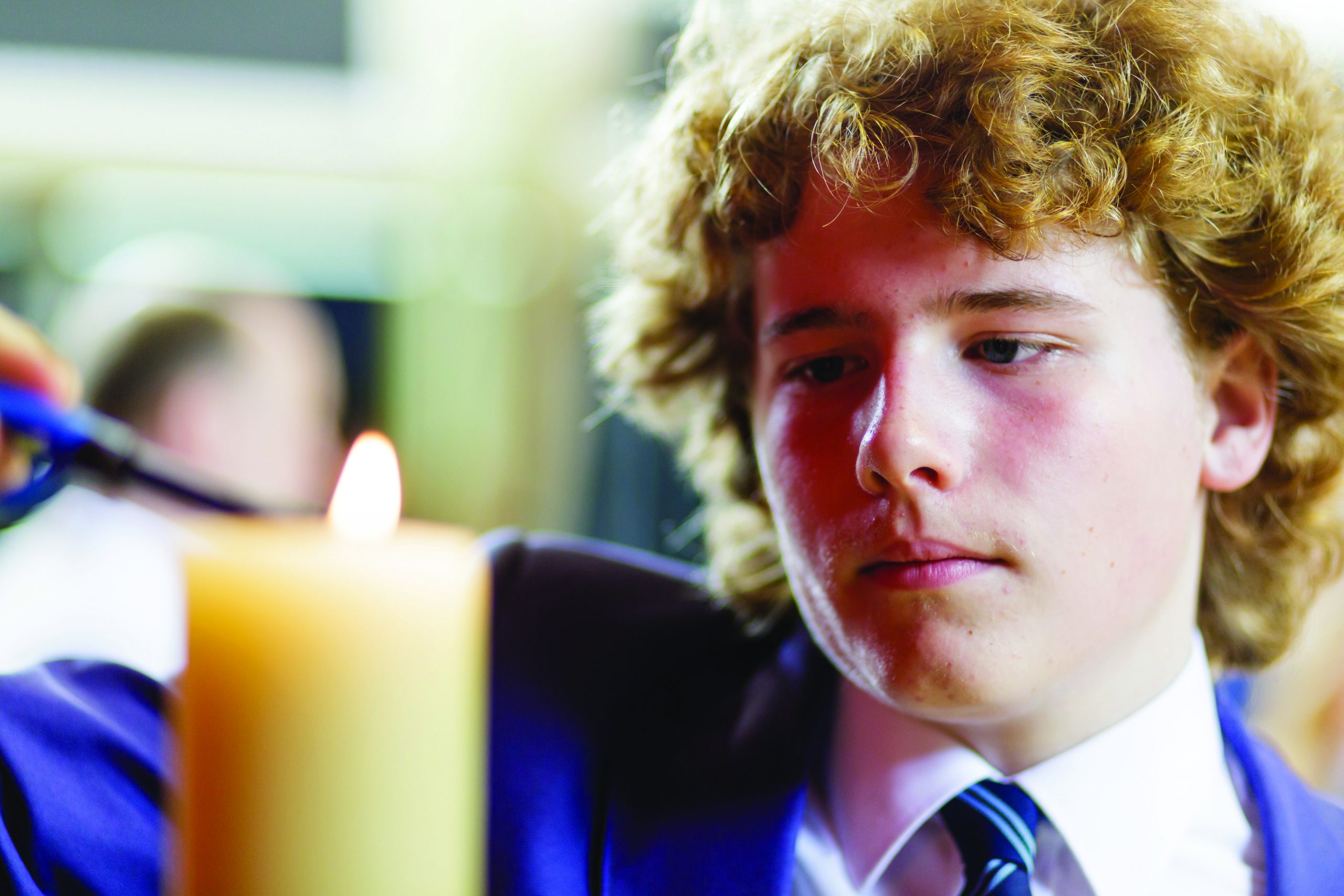 A boy lighting a candle