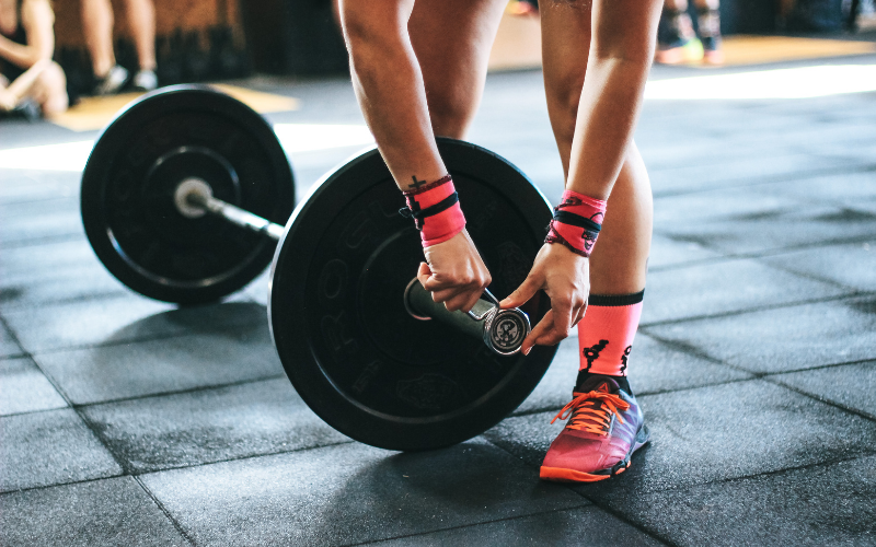 A woman adjusting weights in the gym