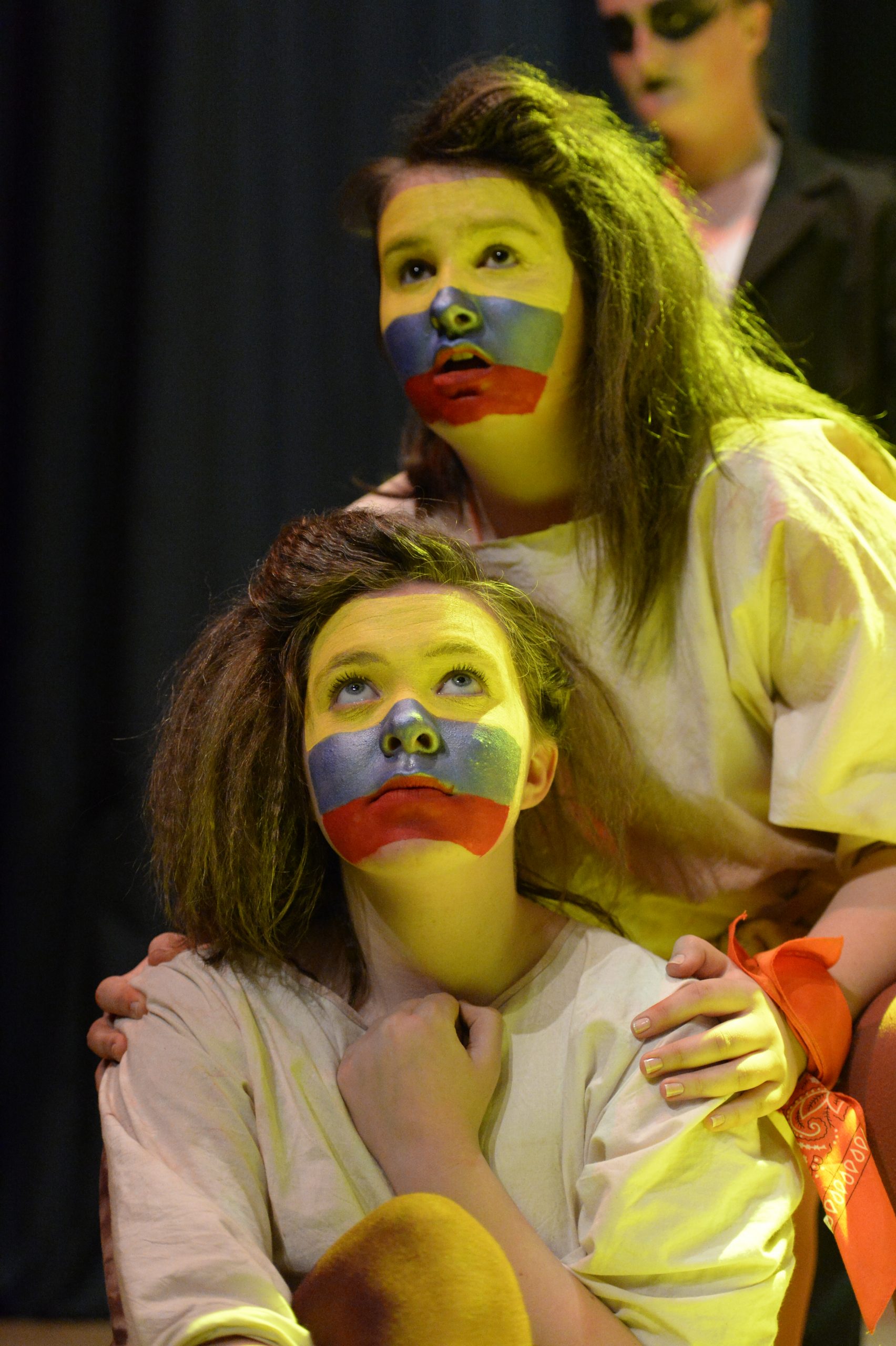 2 girls on stage with blue and red stripes painted on their faces