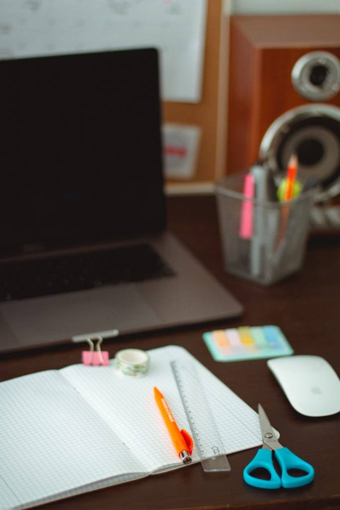 A laptop and stationary on a desk