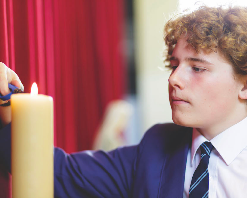 A boy lighting a candle